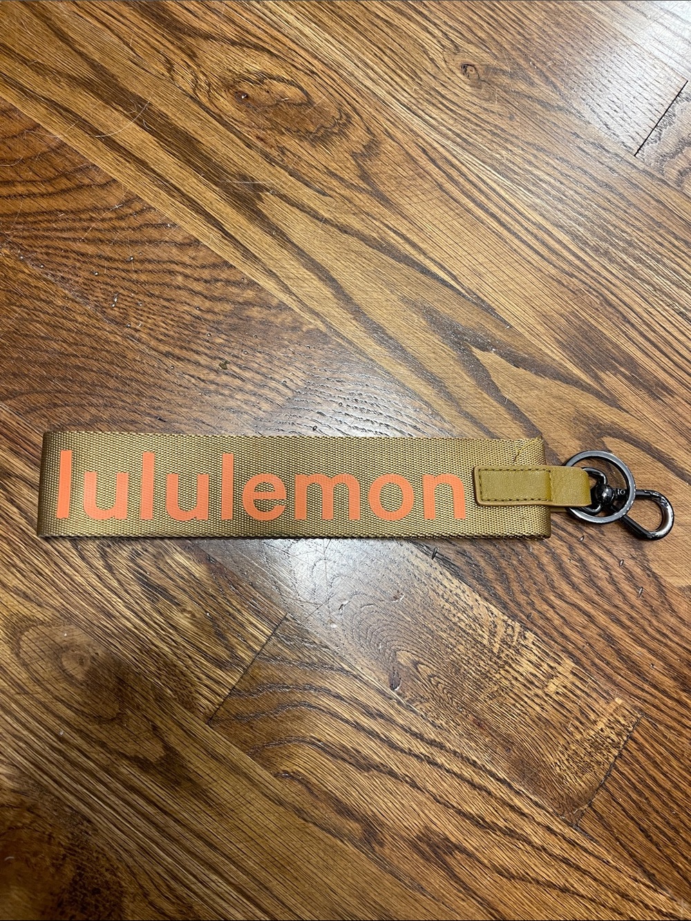 Lululemon tan wristlet key fob with orange logo